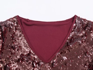 Detail of burgundy V-neck sequin dress showing shimmering material and stitching