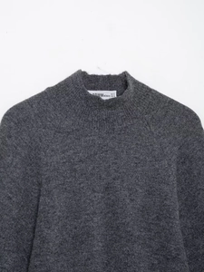 Detail view of deep grey knit sweater featuring a plush texture and crew neck design