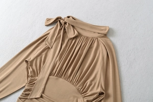 Detail of elegant beige blouse featuring bow-tie collar and pleated chest design