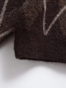 Close-up of fluffy dark brown knit sweater showing soft mohair texture and ribbed cuff details