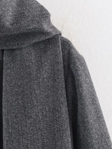 Close-up of deep gray wool blend fabric showing fiber texture and neckline sewing detail