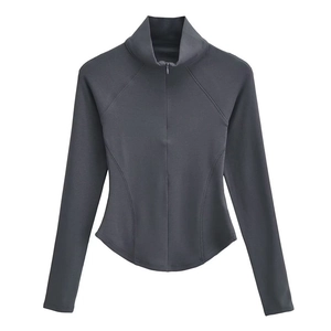 Détails d'une veste de sport grise ajustée avec demi-zip et coutures ergonomiques