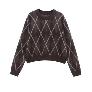 Close-up of brown argyle knit sweater with white diamond pattern and ribbed cuffs