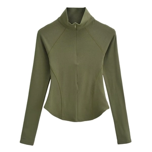 Détail du haut de sport ajusté vert olive avec fermeture éclair et manches raglan