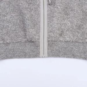 Détail du gilet en polaire grise avec fermeture éclair métallique et ourlet côtelé