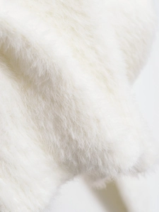 Close-up of premium fluffy white faux fur texture on a knit cardigan for women