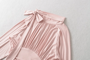 Detail of pink long-sleeve blouse with bow-tie collar and pleated chest design