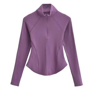 Détail d'un haut de sport violet foncé à manches longues avec zip et ourlet courbé