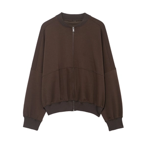 Détail d'une veste marron foncé zippée avec poignets côtelés et coutures décoratives