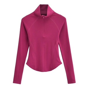 Détail du haut de yoga ajusté avec demi-zip, col montant et tissu rose foncé mat