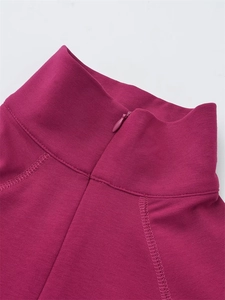 Gros plan d'un haut fuchsia à col montant avec fermeture éclair invisible et tricot