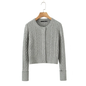 Detail view of a gray cable-knit cardigan with round neck and tonal button closure