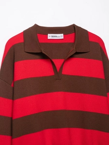 Macro detail of the woven brand neck label on a red and brown striped knit Polo shirt