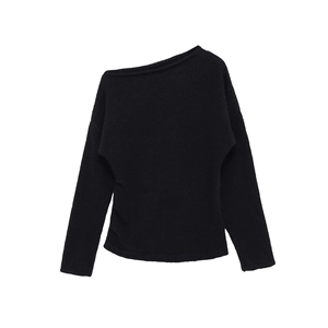 Détail du pull en maille noire à épaule dénudée montrant la texture fine du tissu