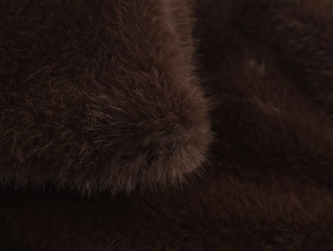 Détail macro de fausse fourrure brun foncé haute densité avec éclat soyeux pour manteau