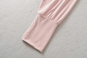 Detailed macro view of the soft light pink knit sleeve with ribbed elastic cuffs and pleats