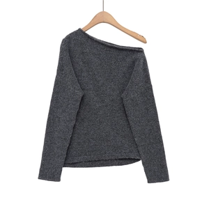 Détails de texture du pull en tricot gris foncé avec épaules dénudées et laine brossée