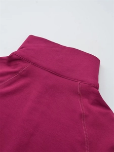 Vue macro des coutures d'un haut rose fuchsia à col montant et texture du tissu