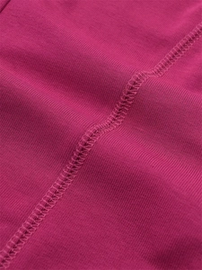Détail du haut rose à manches longues montrant les coutures plates et le tissu coton
