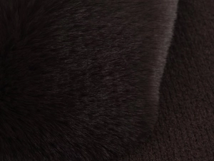Macro close-up of soft black faux fur collar texture with silky synthetic fibers