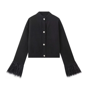 Detail of black knit cardigan with textured silver buttons and faux feather cuffs
