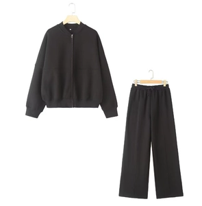 Detail of black zip-up bomber jacket and high-waisted wide-leg sweatpants set