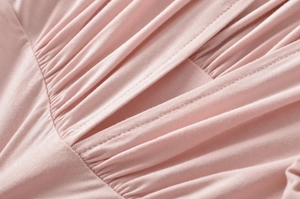 Close-up of pink fabric pleats and double-needle stitching on the elegant blouse