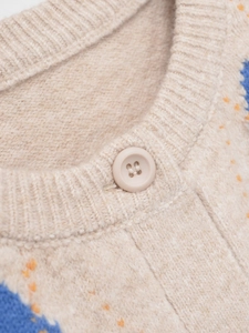 Detail of round neckline and resin button on beige knit cardigan with argyle patterns