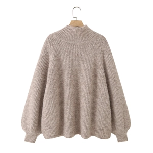 Detail of oatmeal knit sweater showing ribbed turtleneck and raglan sleeve texture
