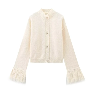 Close-up of cream knit cardigan featuring silver buttons and faux feather trim cuffs