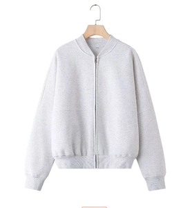 Detail of light gray zip-up bomber jacket with ribbed collar and cuffs on a wooden hanger