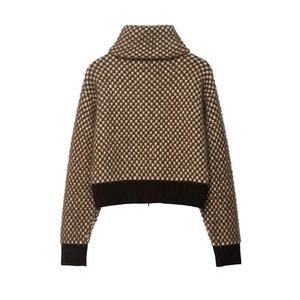 Detail of checkered knit sweater showing brown and beige patterns with ribbed cuffs