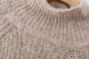 Detailed close-up of soft knit texture and ribbed collar on a women's mauve sweater