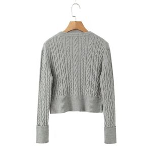 Macro detail of the grey cable-knit texture and ribbed trim on the back of the cardigan