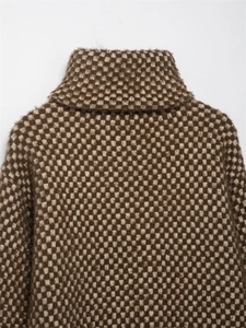 Close-up of brown and cream checkered knit pattern and high collar on winter jacket