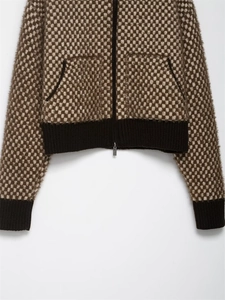 Close-up of textured jacquard knit fabric and metallic zipper on the brown casual jacket