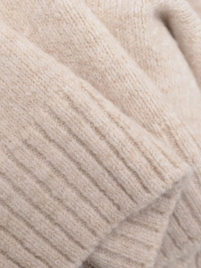 Close-up of ribbed cuffs on beige knit sweater showing fine natural wool texture