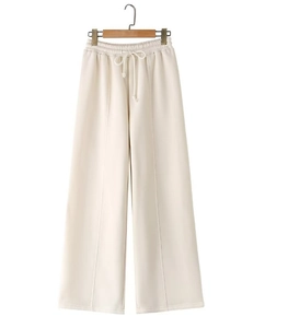 Detail of cream white wide-leg sweatpants with elastic drawstring waist and vertical seam