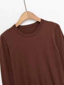 Detail of soft dark brown fine knit fabric on long sleeve crewneck sweater