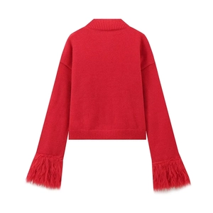 Detail of red knit cardigan featuring thick feather trim cuffs and ribbed textures