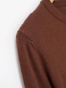 Close-up of the fine knit texture and neckline of this brown casual women's sweater