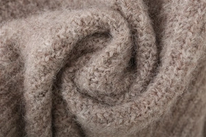 Macro view of light coffee knit texture showing soft long plush fibers and chunky knit style