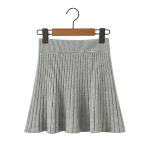 Detail of light grey pleated knit skirt with high elastic waist and A-line silhouette