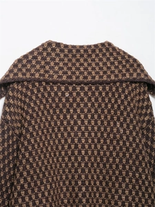 Detail of knitted cardigan showing heart-shaped jacquard patterns and wide lapel collar