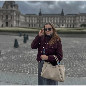Vue détaillée d'une veste en laine bordeaux à boutons dorés et d'un sac cabas texturé