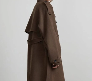 Detail view of brown wool coat featuring storm flap, epaulettes, and belted waist design