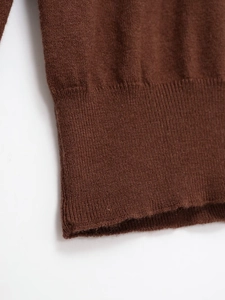Detail of dark brown knitted sweater with premium ribbed cuffs and fine soft texture