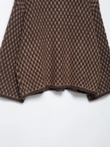 Detailed close-up of retro brown and beige geometric jacquard knit pattern on the fabric