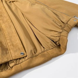 Detail view of mustard suede jacket with smooth lining, metal zipper and elastic hem
