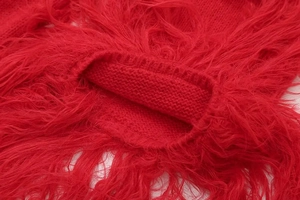 Detail of red fuzzy knit sweater with plush faux fur texture and ribbed cuff design